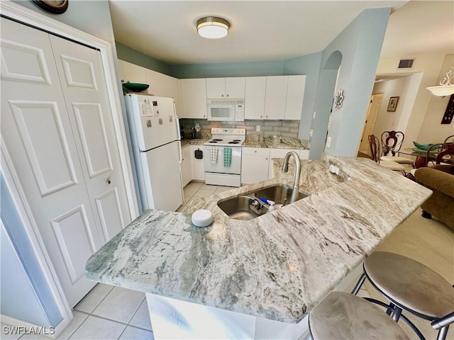 kitchen featuring white appliances, backsplash, white cabinets, sink, and light tile patterned floors