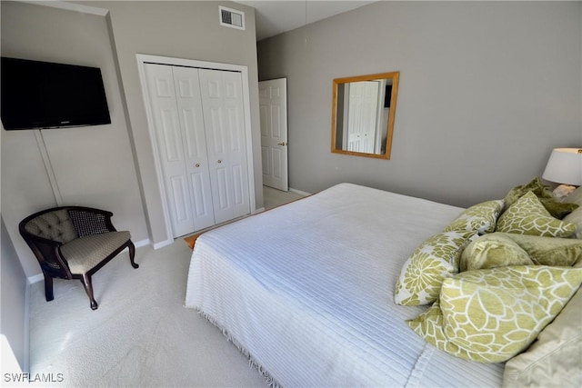 bedroom featuring lofted ceiling, light carpet, and a closet