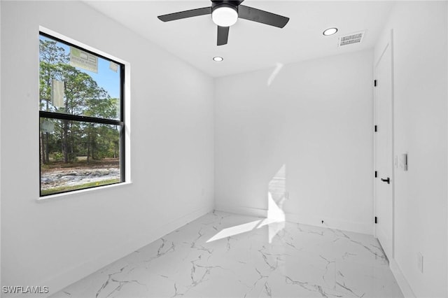 spare room with a wealth of natural light and ceiling fan