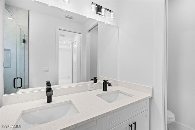 bathroom with vanity, toilet, and an enclosed shower