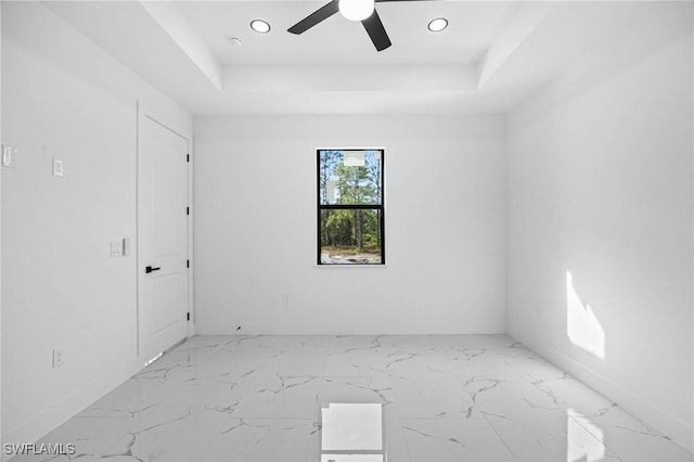 unfurnished room featuring ceiling fan and a tray ceiling