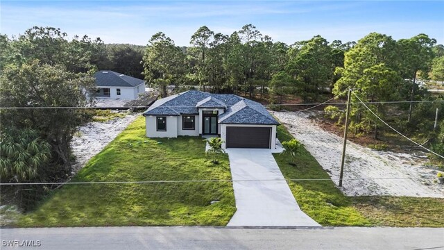 view of front of house featuring a garage and a front lawn