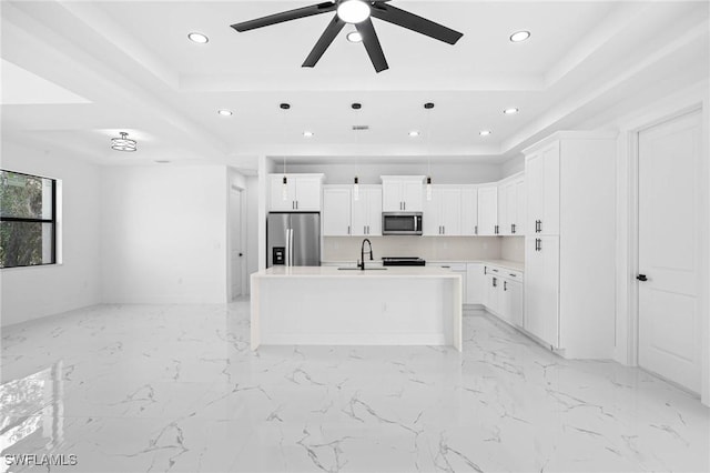 kitchen featuring white cabinetry, a kitchen island with sink, hanging light fixtures, and appliances with stainless steel finishes