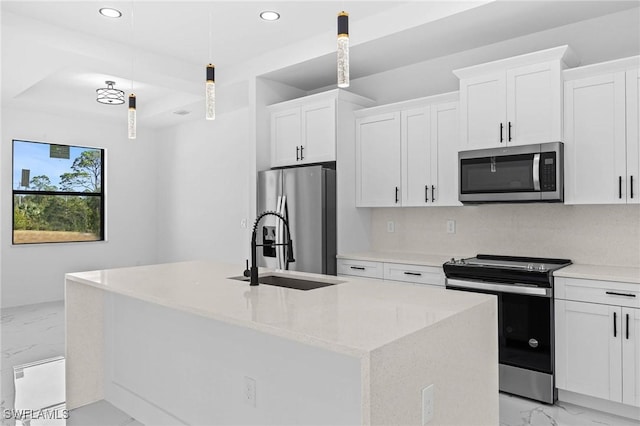 kitchen with white cabinets, decorative light fixtures, stainless steel appliances, and a kitchen island with sink