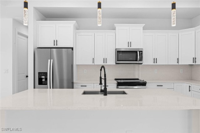 kitchen featuring stainless steel appliances, white cabinetry, hanging light fixtures, and sink