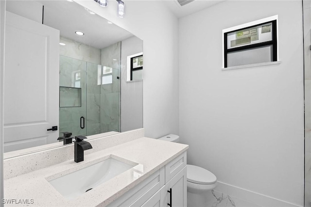 bathroom featuring vanity, toilet, and a shower with shower door