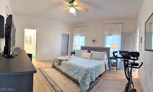 bedroom featuring light wood-style floors, baseboards, and a ceiling fan