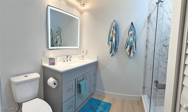 bathroom featuring a shower, hardwood / wood-style floors, vanity, and toilet