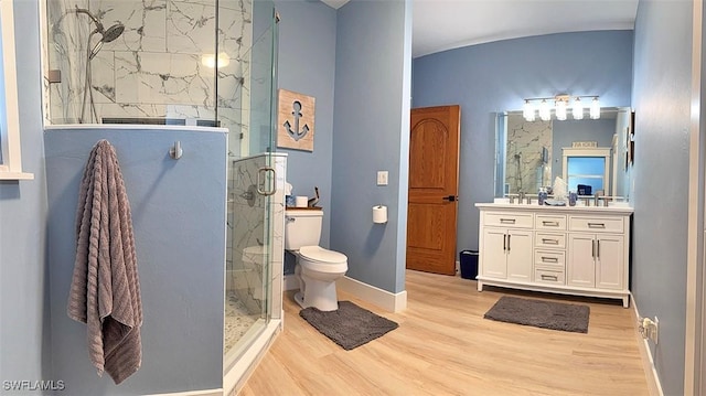 bathroom featuring a marble finish shower, baseboards, toilet, wood finished floors, and vanity