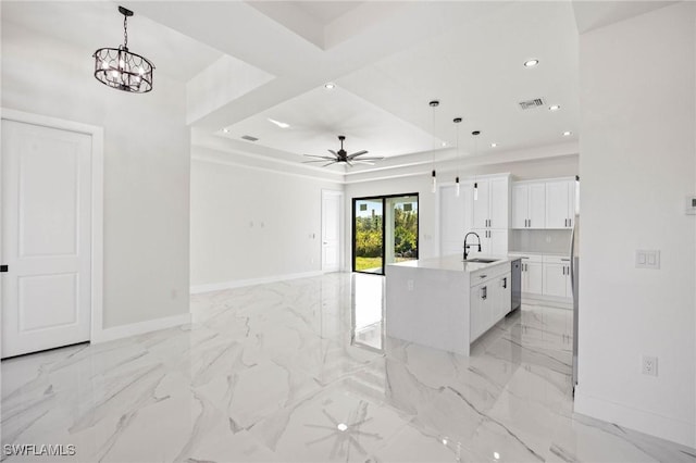 kitchen with white cabinetry, a kitchen island with sink, sink, and hanging light fixtures