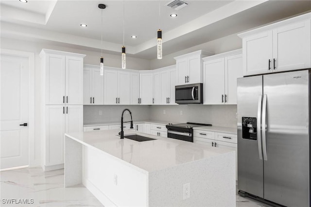 kitchen featuring white cabinets, appliances with stainless steel finishes, decorative light fixtures, and sink