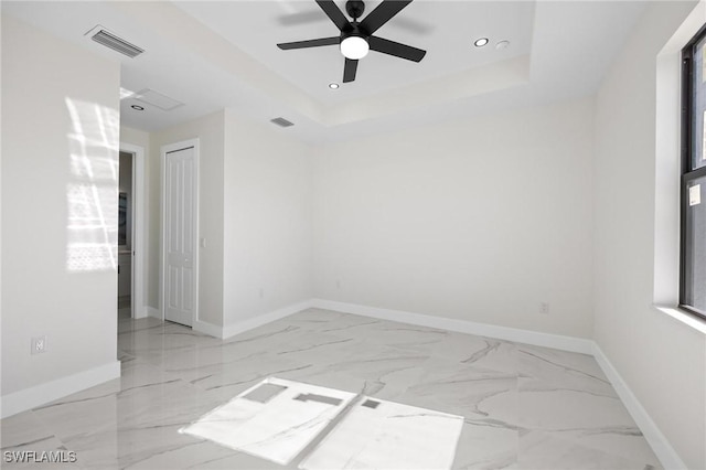 unfurnished room with a tray ceiling and ceiling fan