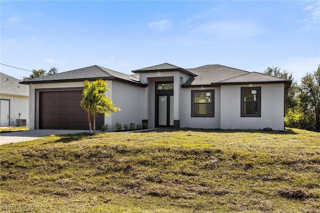 prairie-style home featuring central AC unit, a garage, and a front lawn