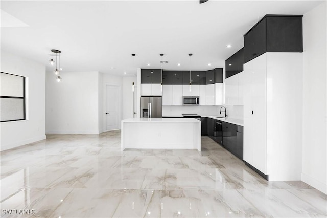 kitchen with pendant lighting, a kitchen island, appliances with stainless steel finishes, and sink