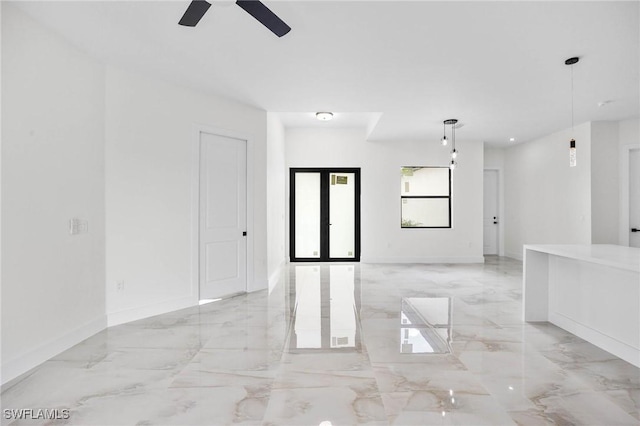 empty room featuring ceiling fan and french doors