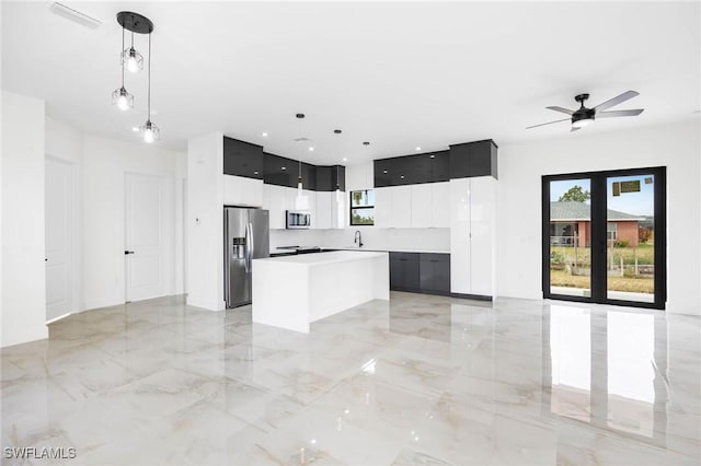 kitchen featuring pendant lighting, sink, ceiling fan, appliances with stainless steel finishes, and a kitchen island