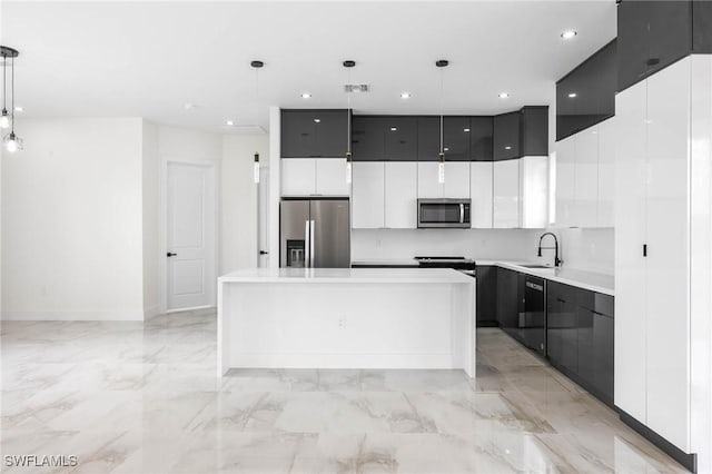 kitchen featuring a center island, white cabinets, sink, hanging light fixtures, and stainless steel appliances