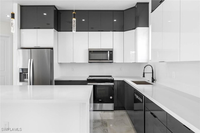 kitchen with pendant lighting, stainless steel appliances, white cabinetry, and sink