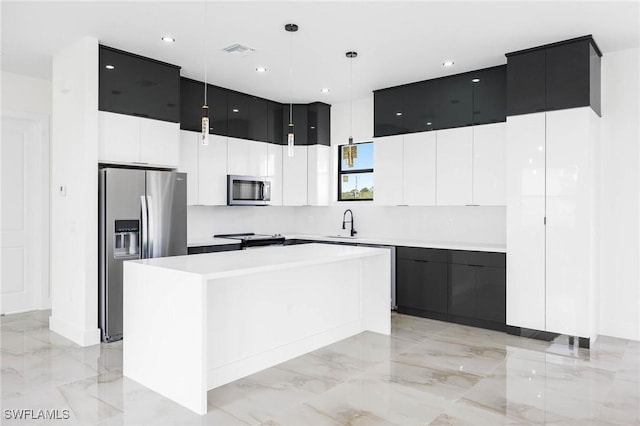 kitchen featuring pendant lighting, a center island, sink, and appliances with stainless steel finishes