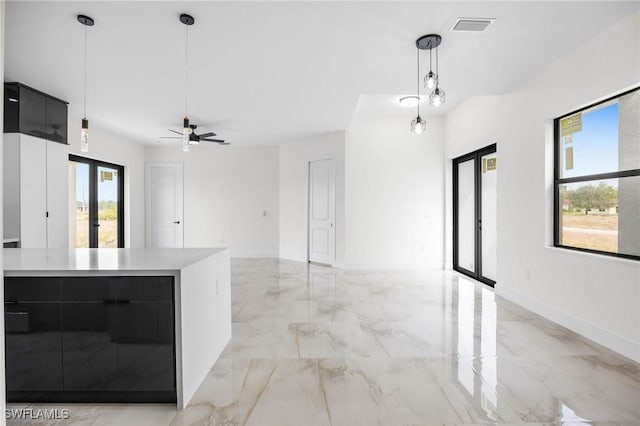 kitchen with french doors, a center island, hanging light fixtures, and ceiling fan