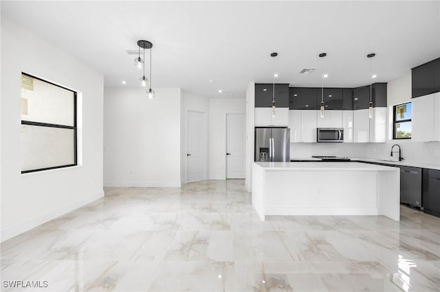 kitchen featuring stainless steel appliances, sink, a kitchen island, and pendant lighting