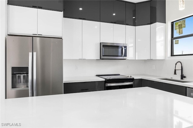 kitchen featuring white cabinetry, sink, and appliances with stainless steel finishes