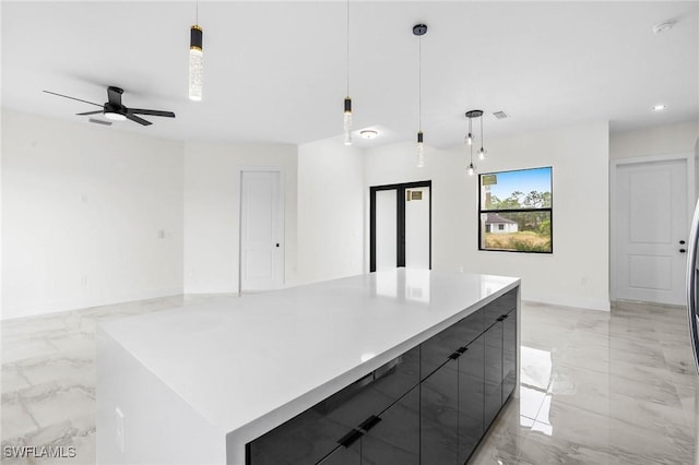 kitchen with decorative light fixtures, ceiling fan, and a spacious island