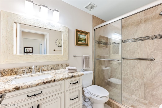 bathroom with vanity, toilet, and a shower with door