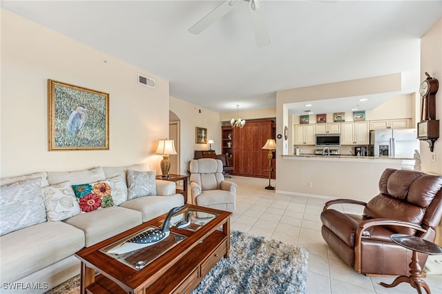 living room with light tile patterned floors and ceiling fan with notable chandelier