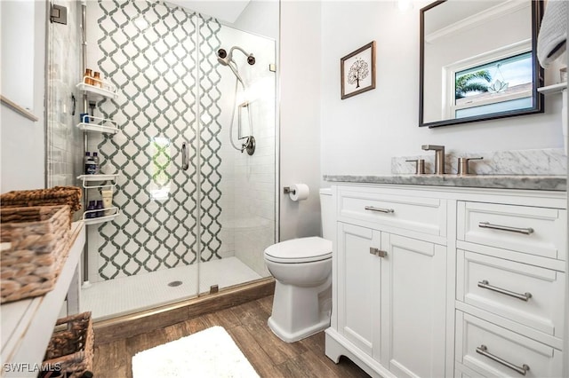 bathroom featuring toilet, vanity, an enclosed shower, and hardwood / wood-style flooring