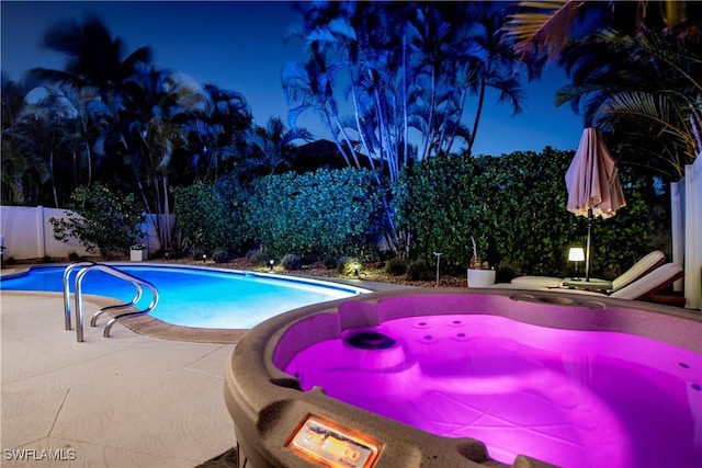 pool at night with a patio area