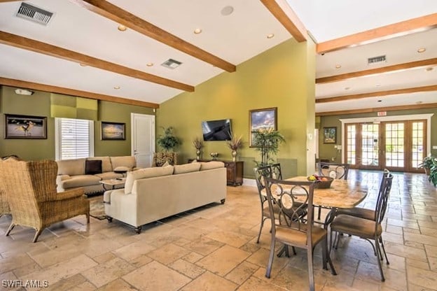 interior space with lofted ceiling with beams, a healthy amount of sunlight, and french doors