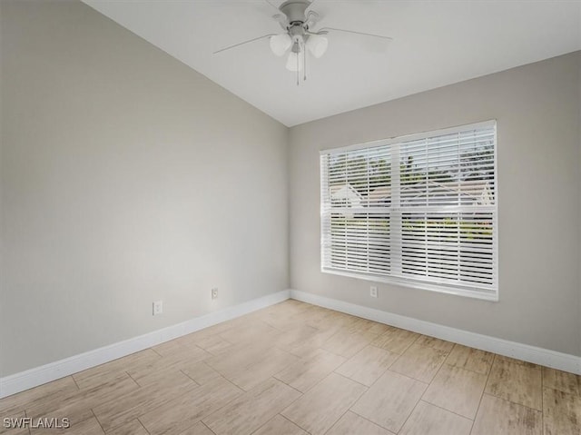 empty room with ceiling fan and vaulted ceiling