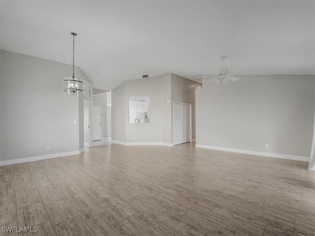 unfurnished living room with ceiling fan with notable chandelier, lofted ceiling, and light wood-type flooring