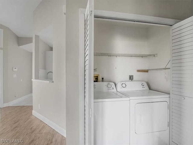 laundry area with light hardwood / wood-style floors and independent washer and dryer