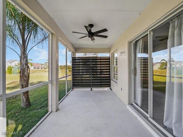 unfurnished sunroom featuring ceiling fan