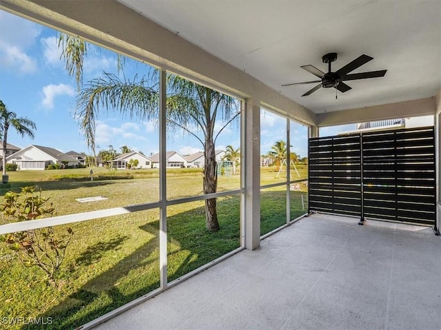 unfurnished sunroom with ceiling fan