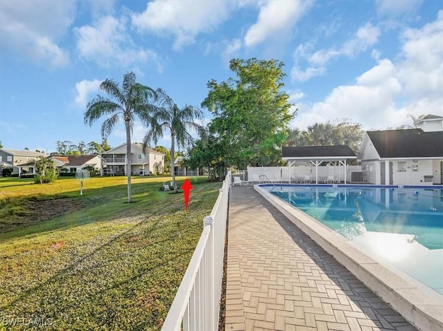 view of swimming pool featuring a yard