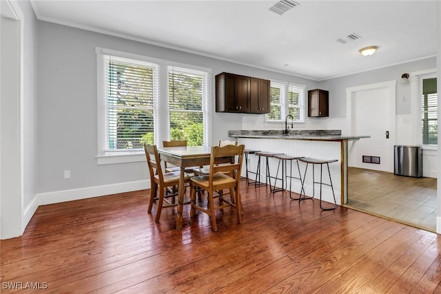 dining room featuring dark hardwood / wood-style flooring and ornamental molding