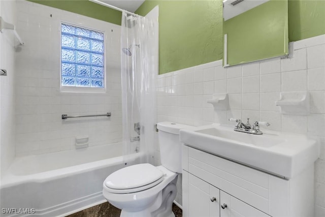 full bathroom with vanity, toilet, tile walls, and shower / bath combo with shower curtain