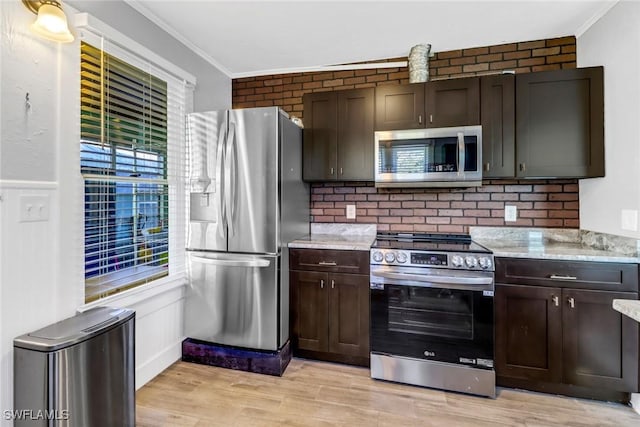 kitchen with crown molding, dark brown cabinets, stainless steel appliances, and light hardwood / wood-style flooring