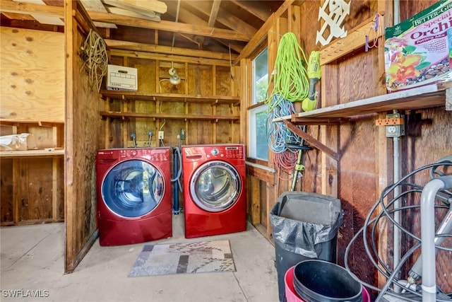 clothes washing area featuring washing machine and dryer and wooden walls