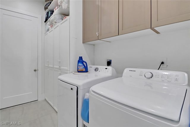 washroom with washing machine and dryer and cabinets