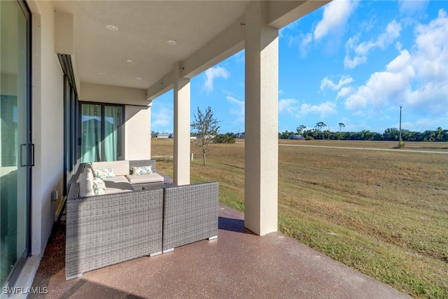 view of patio with an outdoor living space and a rural view