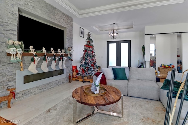 living room featuring a chandelier, french doors, a raised ceiling, and ornamental molding