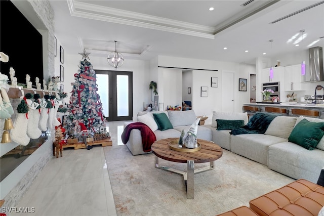 tiled living room featuring a tray ceiling, crown molding, and sink