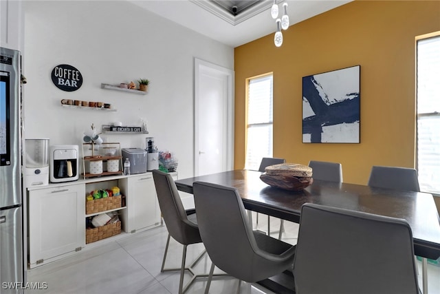 dining area with light tile patterned floors and crown molding