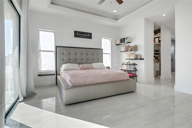 bedroom featuring a raised ceiling, ceiling fan, and ornamental molding