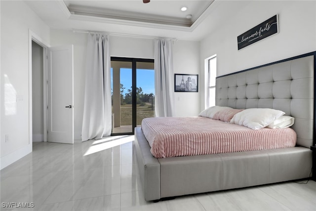 bedroom featuring access to outside, crown molding, and a tray ceiling