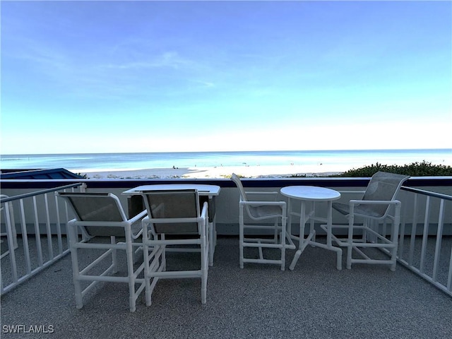 view of patio / terrace featuring a water view and a beach view